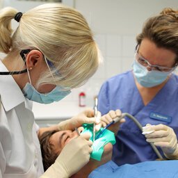 Eine Zahnärztin der Bundeswehr bei der Arbeit an einem Patienten