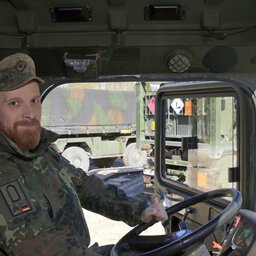 Ein Soldat und Kraftfahrer sitzt am Steuer eines Bundeswehrfahrzeugs