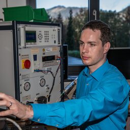 Ingenieur mit blauem Hemd arbeitet an einem technischen Gerät