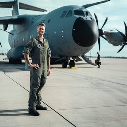 Ein Pilot der Bundeswehr steht vor einem Transportflugzeug.