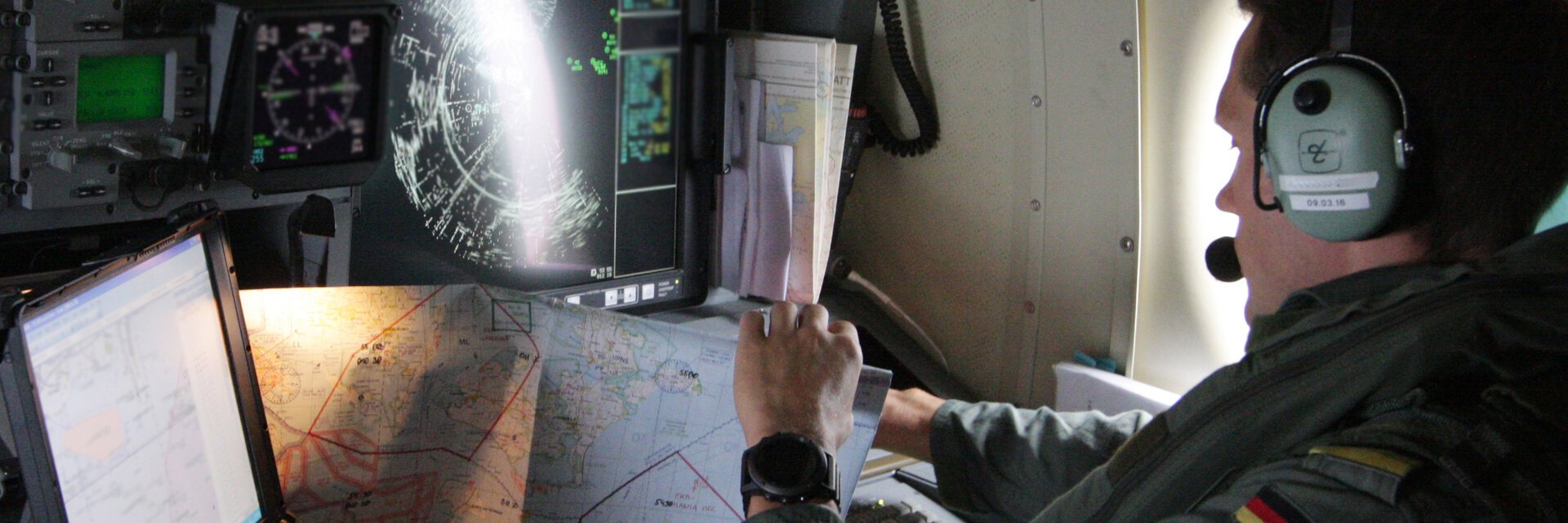 Soldat mit Landkarten sitzt in einem Militärflugzeug