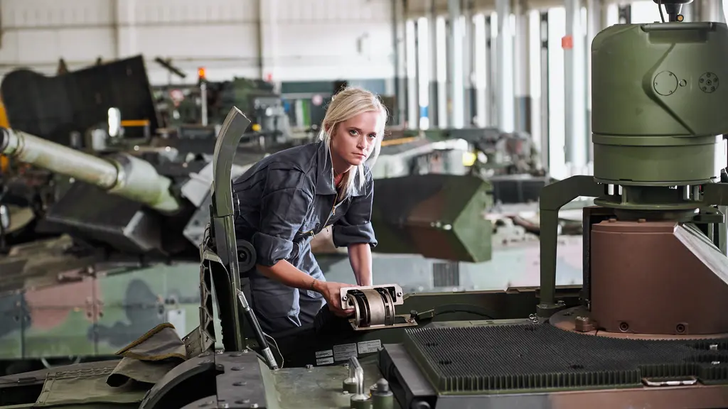 Eine Soldatin bei Wartungsarbeiten an einem Panzer