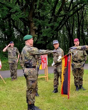 Mehrere Soldaten stehen beim Feldgelöbnis auf einer Wiese
